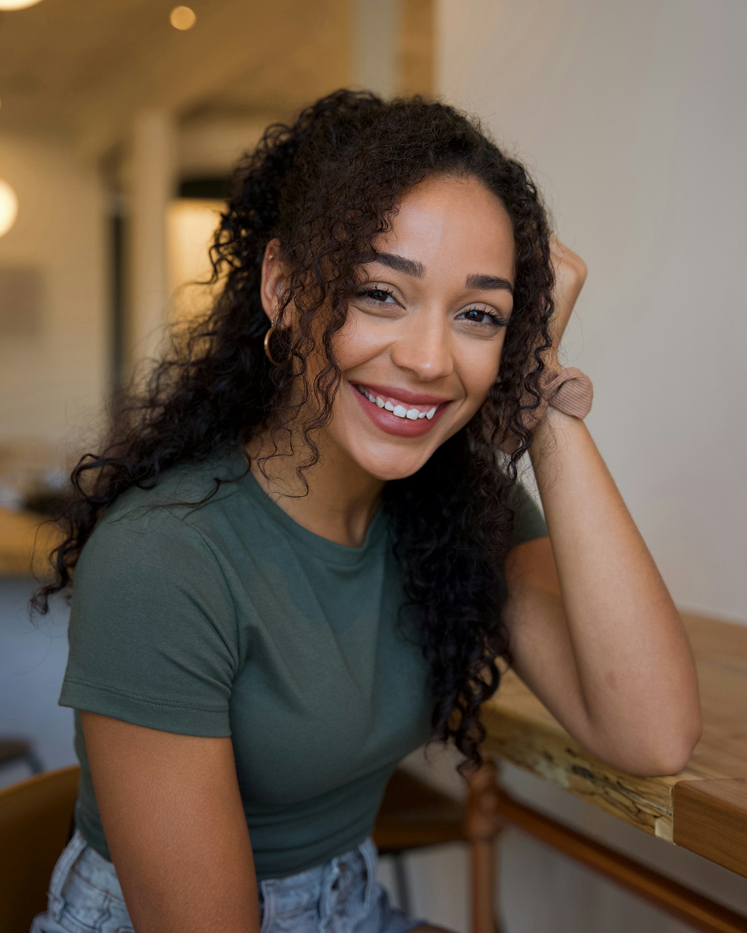 A patient sitting relaxed and smiling in daylight, at ease rather than in a dental chair.