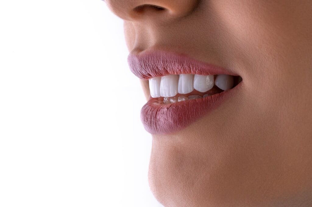 Close-up of a person smiling, showing clean, natural-looking teeth.